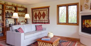 A large living room with a geometric rug a large couch and fireplace