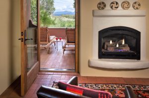 A gas firplace and a patio with two chairs and mountain views