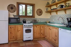 An L shaped kitchen with dishwasher, range, and window