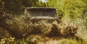 Off road Jeep splashing through a mud puddle