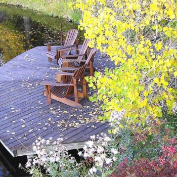 Adirondack chairs on the dock at Blue Lake Ranch with fall foliage.
