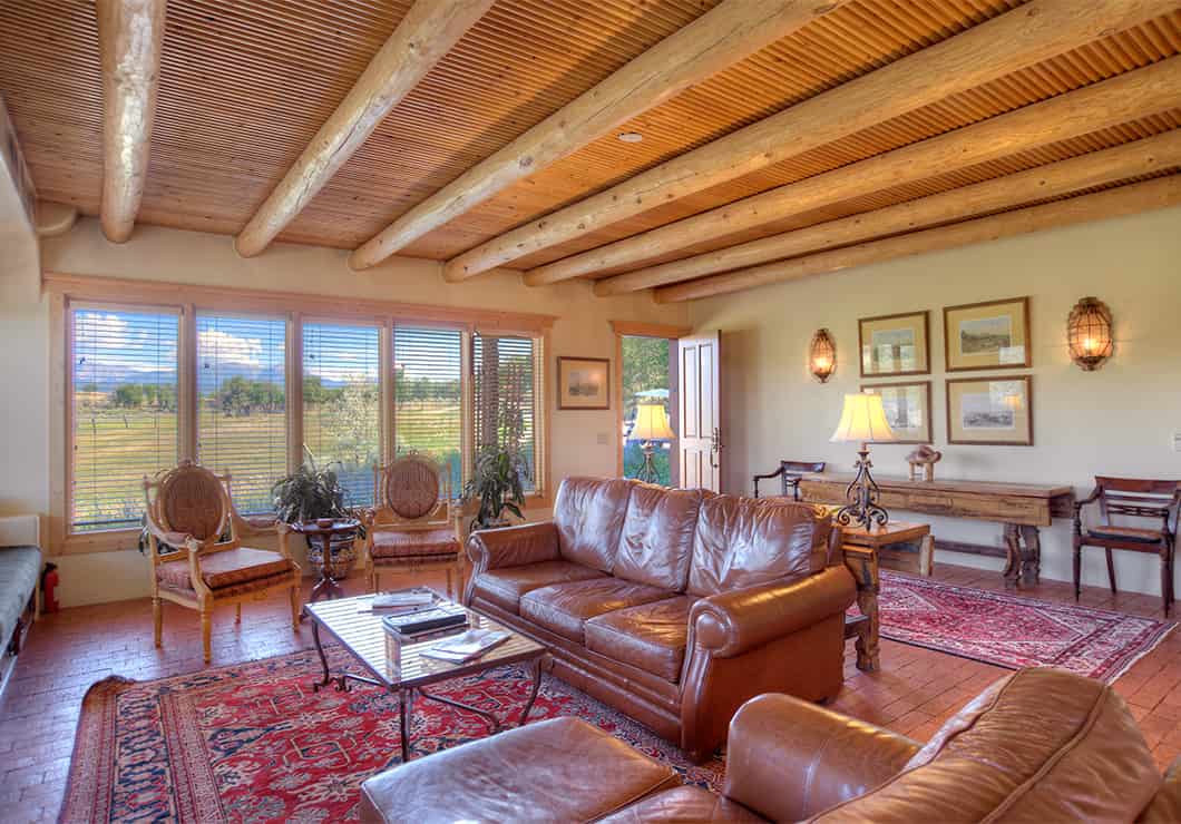 A large living room with leather couches and a view of the mountains